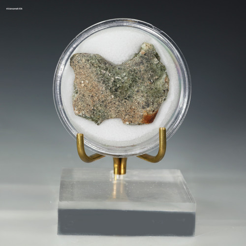 Front-facing side of trinitite green black 6.1 grams on a display stand, for sale at Sciencemall-USA