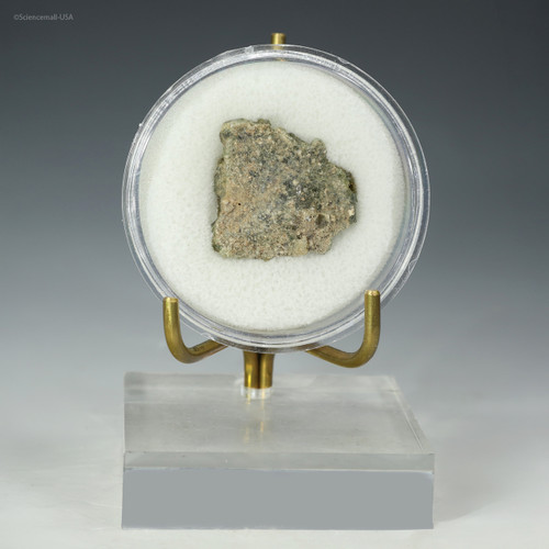 Front view of trinitite green, black, metal, bleb, on a display stand at Sciencemall-USA