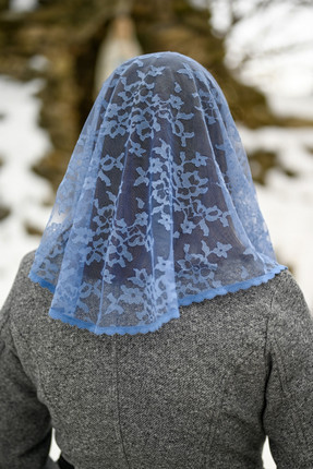 Model wearing the Marian Blue Starter Veil by Veils by Lily, a soft and simple Catholic chapel veil perfect for beginners.