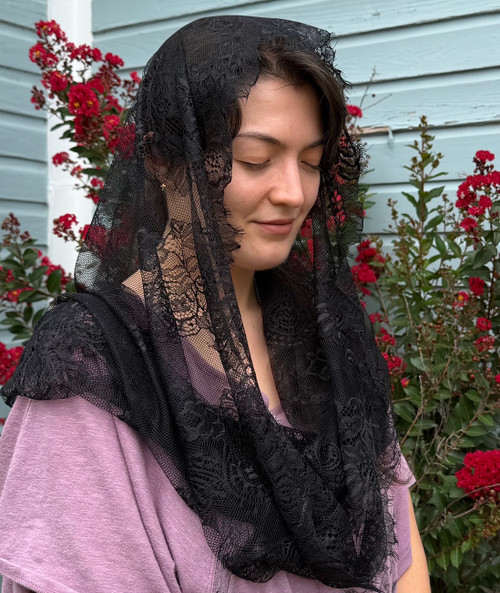 Side view of the St. Cecilia black lace infinity veil worn over the head.