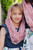 Front view of a young girl wearing a Dusty Rose children's chapel veil on her head, showcasing the soft lace gracefully framing her face.