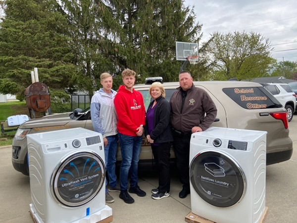 GEA4Heroes recipients Kevin and Mindy Brown of Hartford, Ind., take a photo with their sons and new washer and dryer.