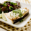 Alaska halibut steaks with a salad and lime wedges.