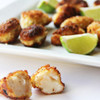 Breaded Alaska cod chunks with lime wedges.