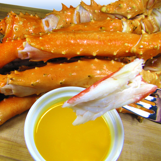 Golden king crab on a fork ready to dunk in hot melted butter.