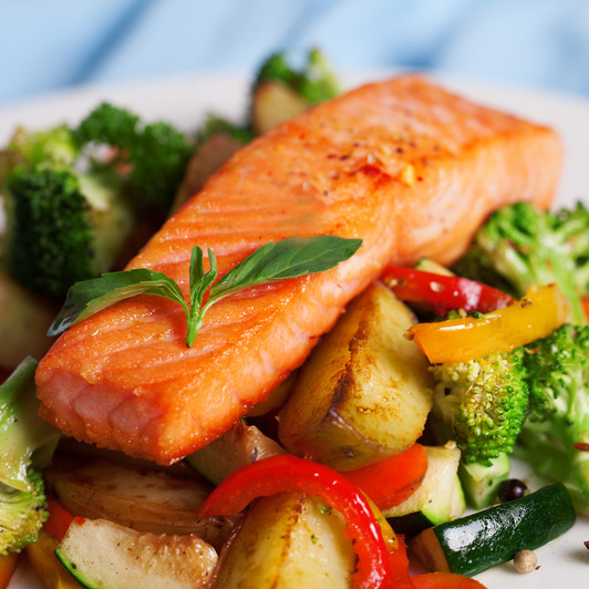 A broiled Patagonia king salmon fillet on a bed of fresh vegetables.