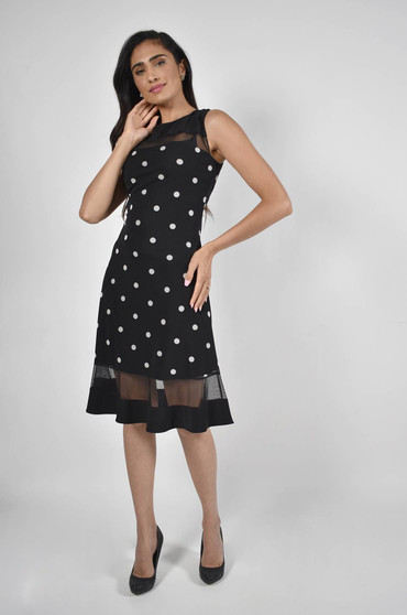 Model wearing the Frank Lyman polka-dot knit dress with black mesh inserts