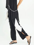 Model showing the side of the Drawstring Joggers from Sassy in the colors black and white