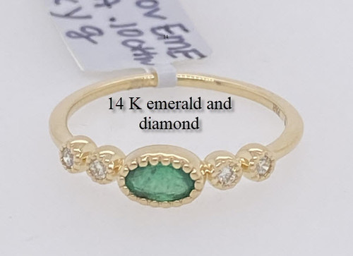 14 karat yellow gold oval cut emerald and four round brilliant cut diamond ring.