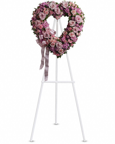 In the shape of a heart, and accented with a pink satin ribbon, this garden of delicate blooms is a tender and classic tribute to a precious life, and a cherished expression of love and sympathy.
Beautiful flowers such as light pink roses, hydrangea and miniature carnations mix with lavender chrysanthemums on an open heart-shaped wreath.
Orientation: One-Sided