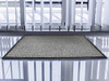 Floortex Doortex Advantagemat, Indoor Entrance Door Mat, 60cm x 90cm, Grey, placed at an entrance with a tiled floor and vertical blinds in the background.
