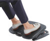Kensington Adjustable Ergonomic Foot Rest - SoleMate Plus, under desk foot rest for improved posture, sciatic and orthopedic relief, black color with dimensions 55 x 36 x 9 cm, showing a person resting their feet on the footrest while seated at a desk.