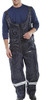 COLDSTAR FREEZER BIB TROUSERS NAVY BLUE S, a man wearing navy blue bib trousers designed for freezer work with adjustable straps and reflective accents.