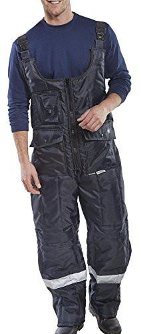 COLDSTAR FREEZER BIB TROUSERS NAVY BLUE S, a man wearing navy blue bib trousers designed for freezer work with adjustable straps and reflective accents.