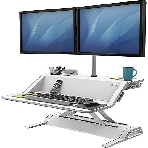 Fellowes Lotus Height Adjustable Standing Desk Converter - Sit Stand Desk with Smooth Lift Technology - Max Weight 15.8KG - White, featuring dual monitors mounted on the adjustable desk with a keyboard, mouse, smartphone, coffee cup, and office supplies on the surface.
