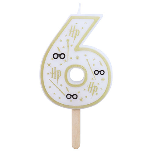 A white, gold, and black number six candle with Harry Potter themed design, featuring lightning bolts, wands, stars, and glasses.