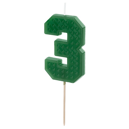 A building block patterned green candle in the shape of a number 3