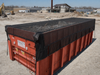 Pioneer 9ft8in x 28ft Mega Mesh Tarp with integrated side flaps installed on roll-off container at construction demolition site
