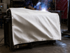 White Fiberglass Welding Blanket in use - protecting equipment from weld spatter