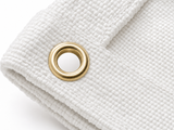 Brass grommet close-up on white fiberglass welding blanket - 24 inch spacing