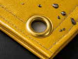 Close-Up: Gold Acrylic Coating with Cooled Slag Droplets and Brass Grommet