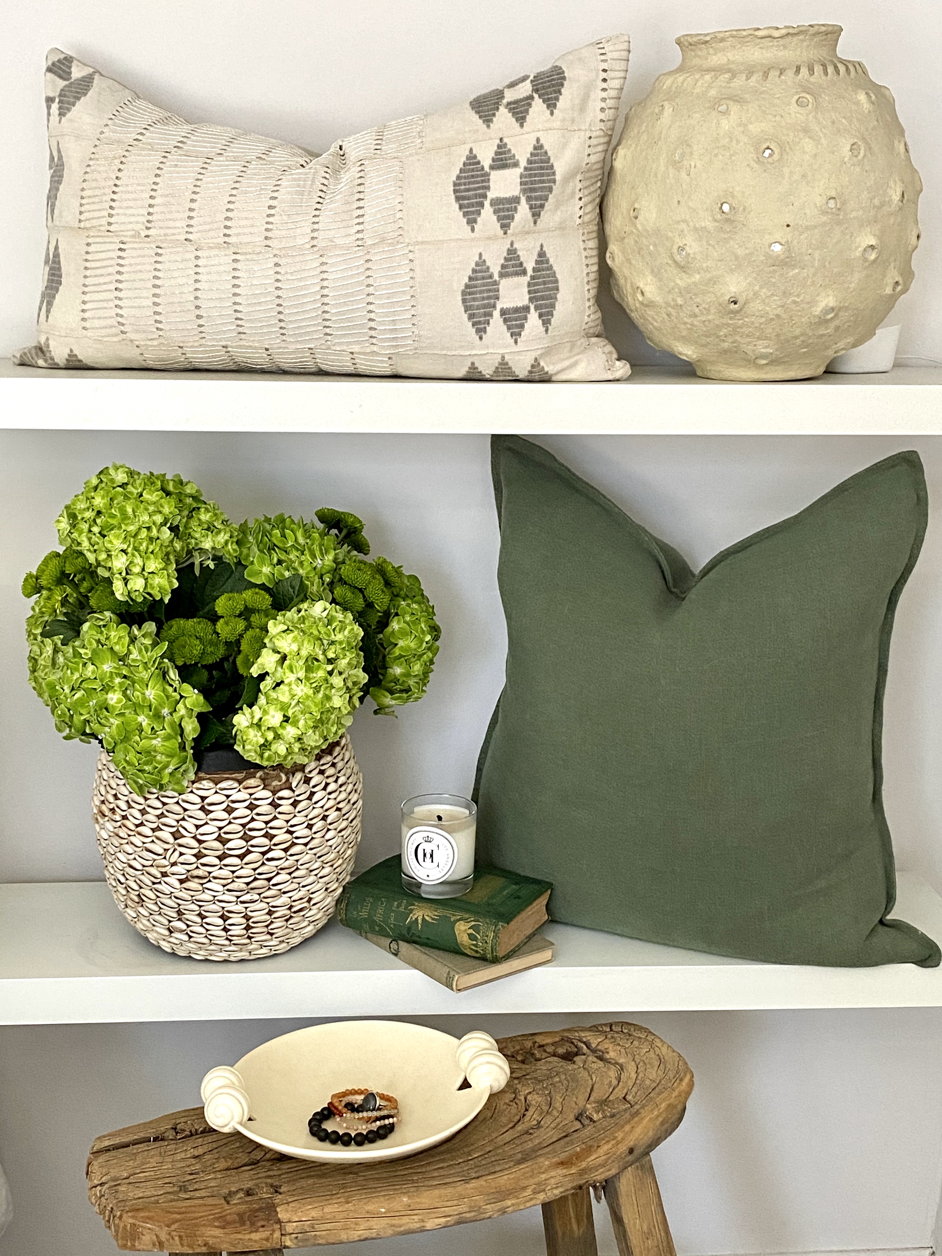 Pillows, pots, and home decor with green and neutral tones.