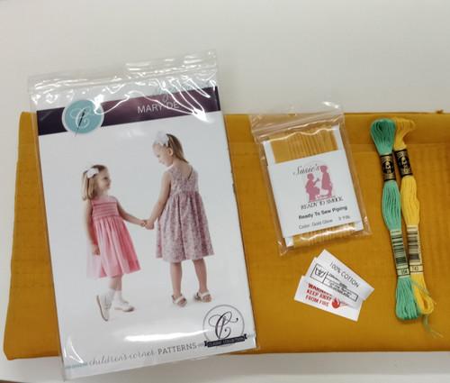 Mary De pinafore kit, Everything you need to make the Mary De Pinafore, What's included, Mary De pattern by Children's Corner Store - Sizes 6 month - 3 years, Baby needlecord fabric in ochre - enough for the largest size, 1 x Lemonade piping, 1 x DMC 743 stranded thread, 1 x DMC 954 stranded thread, 10 rows pleated, Fire label, 100% cotton label, Hand Wash label, The fabric has been pleated along the top edge for the full width of the fabric, to cut out place the pattern piece on the fabric as normal and cut out, then pull the pleater threads up and tie to the required width, Kit also available without the pattern if you already have the pattern