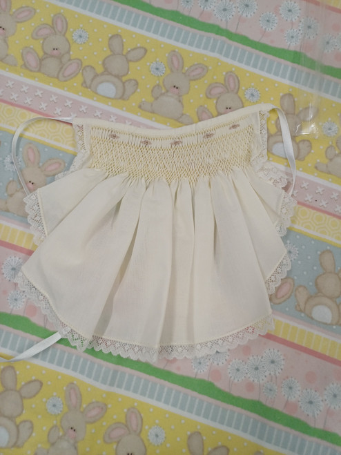 A pretty hand smocked bib with spot and wave lace, Size 0-6 month, Made in Rice coloured imperial batiste, Wash at 30 degrees