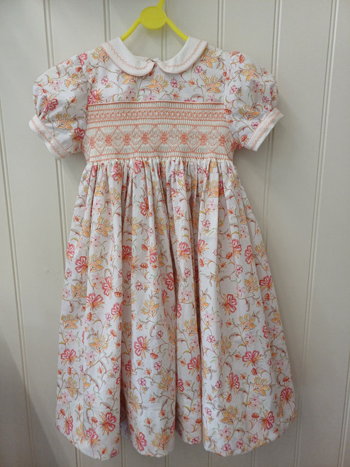This is a child's hand smocked dress in size 6 years, I used the pink and orange floral London Lawn which is 100% cotton, Hand smocked on plain cream fabric so that the, smocking shows up best, Lovely subtle colours to blend with the colours in the fabric, Piped collars and cuffs, Feather stitch on the collars and cuffs, Belt loops at the back, Wash at 30 degrees