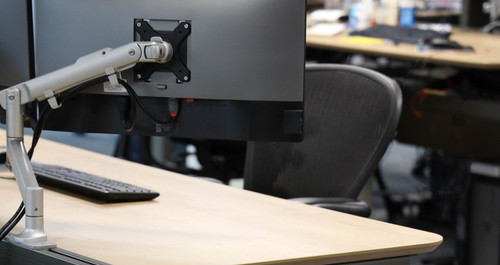 ATDEC AWMS-DB White monitor arm supporting a 32" white screen on a modern office desk.