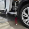 Urban Xplorer mobility cane for the blind fully extended with a passenger sitting in a vehicle getting ready to close the door.