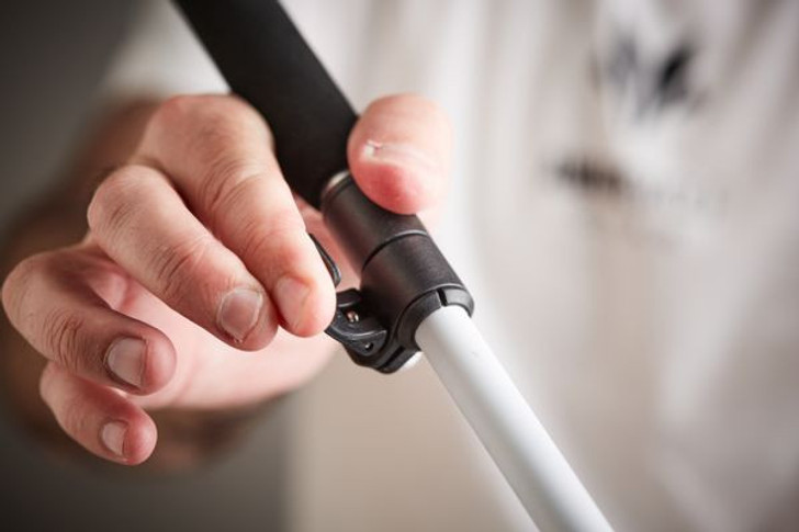 Person gripping the flip lock section of the Urban Xplorer mobility cane getting ready to secure adjusted length. Adjustable cane height.