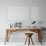 Modern minimalist workspace featuring a wooden desk with a white top, a matching wooden stool, a black desk lamp, and decor including a small plant and a vase, with two clear acrylic dry erase boards mounted on a light gray wall.