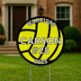 Round volleyball yard sign with “CARSON #25” and “2025” printed on a bright yellow background, shown on grass with a blurred green background.