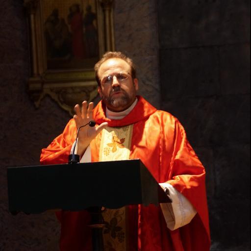 Photo of author Monsignor Pope standing at a poduim speaking.