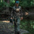 hunter walking in the woods along a creek