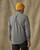 Model wearing a Filson Light Weight Alaskan Guide Shirt in Light Charcoal Plaid, rear view