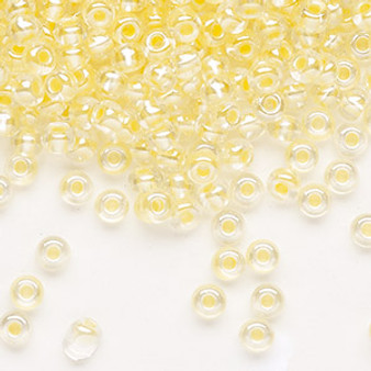 Seed bead, Preciosa Ornela, Czech glass, translucent color-lined pastel yellow luster, #6 rocaille. Sold per 50-gram pkg.