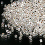 Seed bead, Dyna-Mites™, glass, silver-lined translucent rainbow clear, #11 round with square hole. Sold per 40-gram pkg.