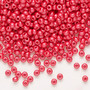 Seed bead, Preciosa Ornela, Czech glass, opaque chalkwhite PermaLux dyed red, #8 rocaille. Sold per 50-gram pkg.