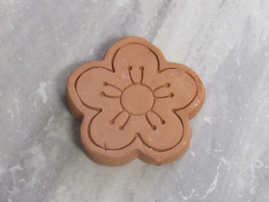 A finished brown terracotta clay sugar saver- small flower bloom. On a gray marble look background. A finished brown terracotta clay sugar saver- small flower bloom. On a gray marble look background.