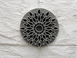 A mandala accent (design 5) clay pottery texture stamp. On a finished concrete wall look background. A mandala accent (design 5) clay pottery texture stamp. On a finished concrete wall look background.