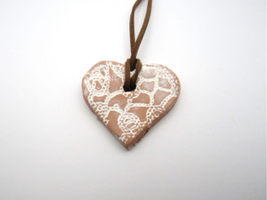 An aromatherapy heart shaped pendant terracotta diffuser for essential oils. On a brown cord necklace. An aromatherapy heart shaped pendant terracotta diffuser for essential oils. On a brown cord necklace.
