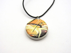 A ceramic round abstract pendant necklace, featuring fall colors. On a black cord necklace. A ceramic round abstract pendant necklace, featuring fall colors. On a black cord necklace.
