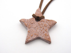 An aromatherapy small star shaped pendant-terracotta diffuser for essential oils. On cord necklace. An aromatherapy small star shaped pendant-terracotta diffuser for essential oils. On cord necklace.