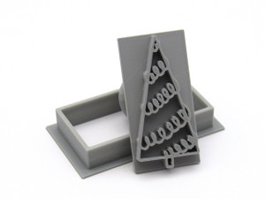 A Curly Rectangle Christmas Tree pendant stamp with cutter. With stamp tilted on top of cutter. A Curly Rectangle Christmas Tree pendant stamp with cutter. With stamp tilted on top of cutter.