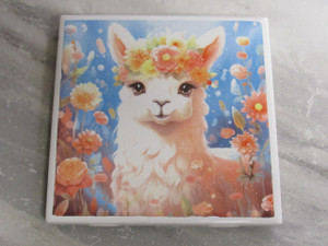 A handmade Llama Alpaca Ceramic Coaster Hot Pad Trivet. On a gray marble look background. A handmade Llama Alpaca Ceramic Coaster Hot Pad Trivet. On a gray marble look background.