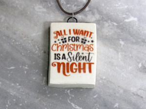 A fun Christmas Handmade Ceramic Pendant Necklace with the words "All I want For Christmas is a Silent Night. On a black cord necklace. A fun Christmas Handmade Ceramic Pendant Necklace with the words "All I want For Christmas is a Silent Night. On a black cord necklace.