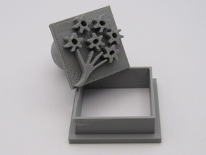 A doodle flower bouquet square clay pottery stamp with cutter. Shown with stamp tilted on top of the cutter. A doodle flower bouquet square clay pottery stamp with cutter. Shown with stamp tilted on top of the cutter.