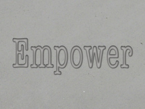 A clay imprint of an inspirational "Empower" clay pottery stamp for slab built pottery mug stamp.
